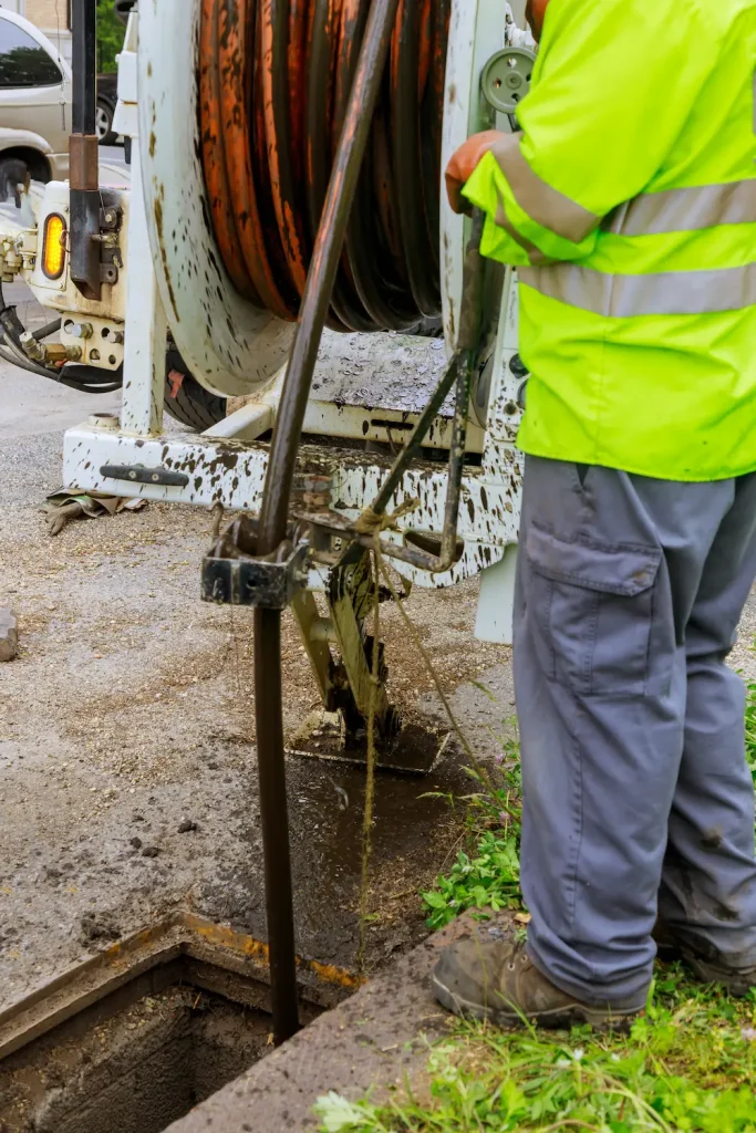 Hydro-jetter being introduced through the sewer outside of a home.