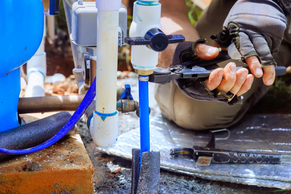 Plumber fixing the pipe on a well pump setup.